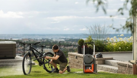 En man som rengör sin cykel med hjälp av en Husqvarna högtryckstvätt PW350