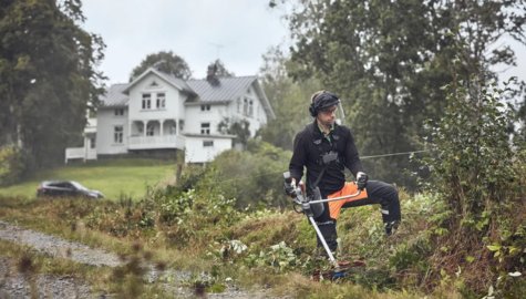 En man som arbetar med en Husqvarna röjsåg